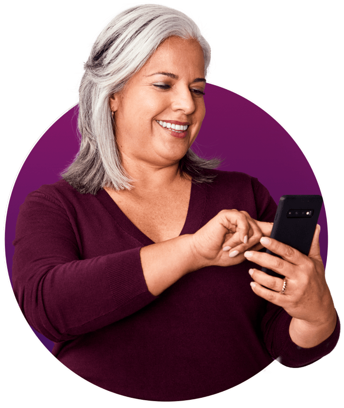 A lady holding a phone and smiling