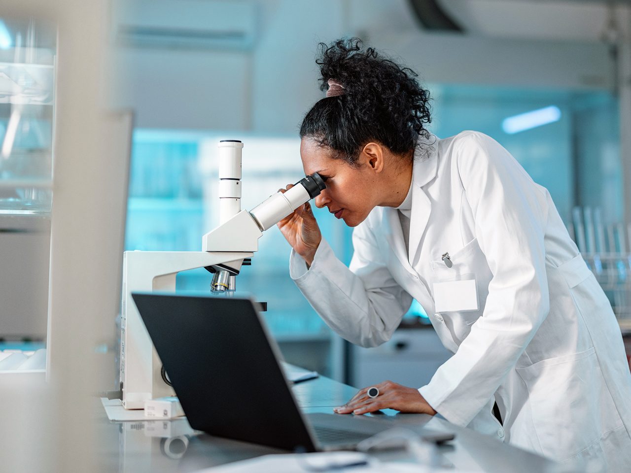 An Astellas scientist examining samples  under a microscope, reflecting the company’s  research-driven mission.