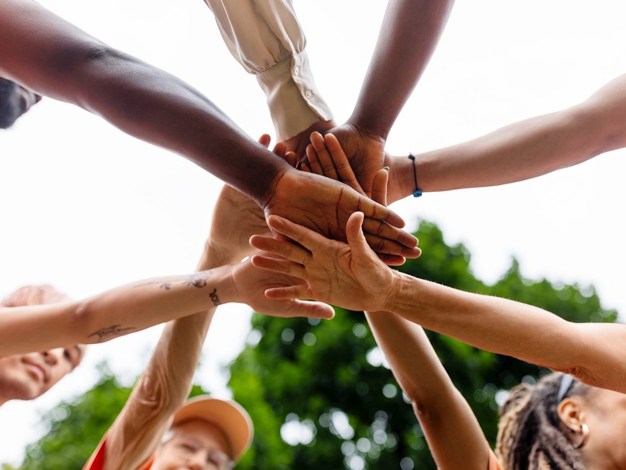 A group of hands joined in unity, symbolizing Astellas’ collaborative and sustainable approach to healthcare.