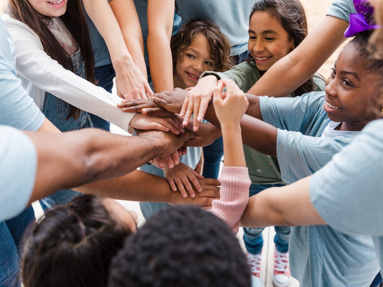 A group of hands joined in unity, symbolizing Astellas’ collaboration and support to improve Access to Health.