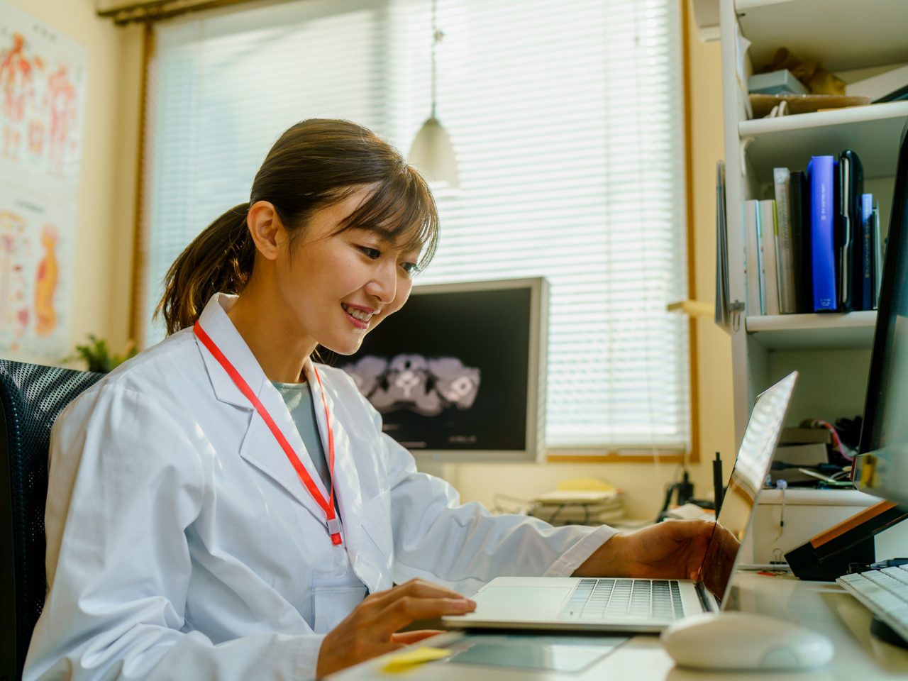 An Astellas scientist works on a computer, researching Access to Medicines.