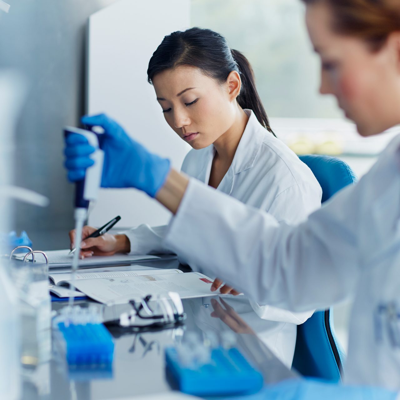 アステラスの研究者たちが研究室でピペットを使用し、初期段階の創薬や有望な新しい治療法の開発を支えています。