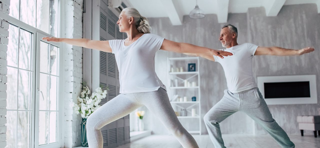 Image of a woman and a man stretching. They are using white clothes