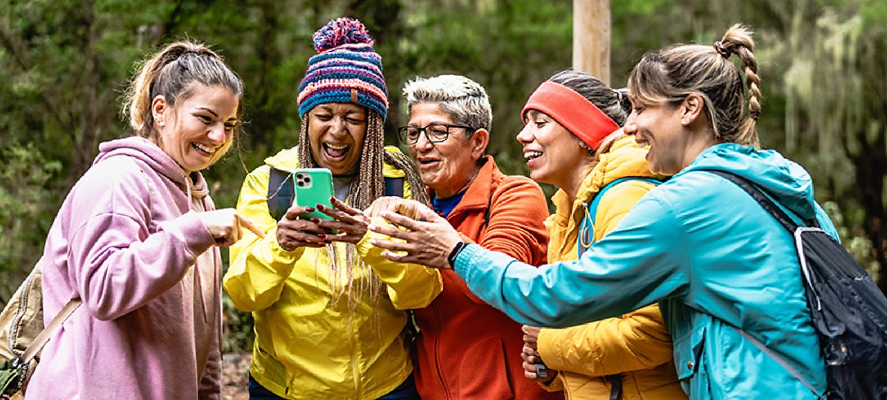 Image of a group of ladies looking to a phone and smiling