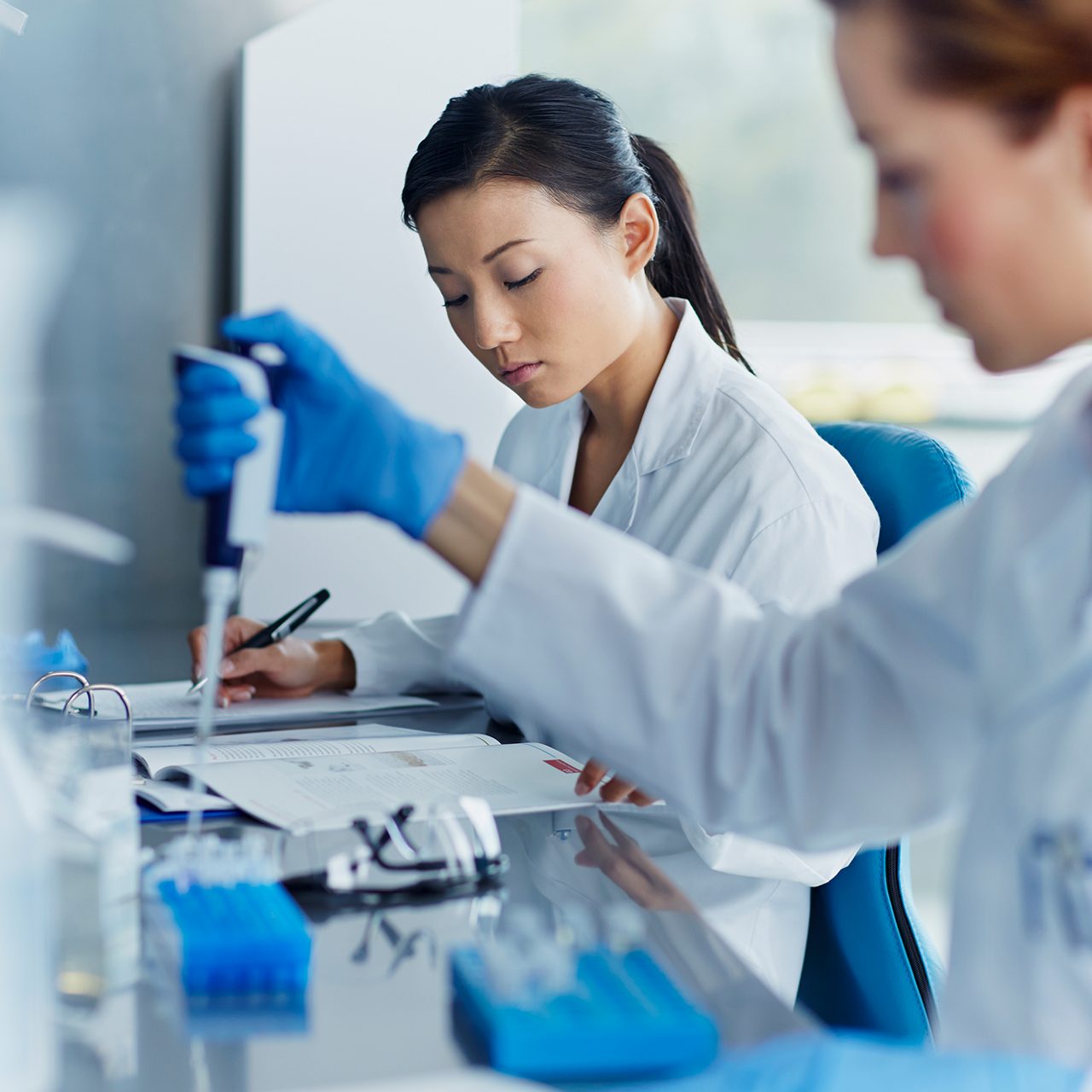 アステラスの研究者たちが研究室でピペットを使用し、初期段階の創薬や有望な新しい治療法の開発を支えています。