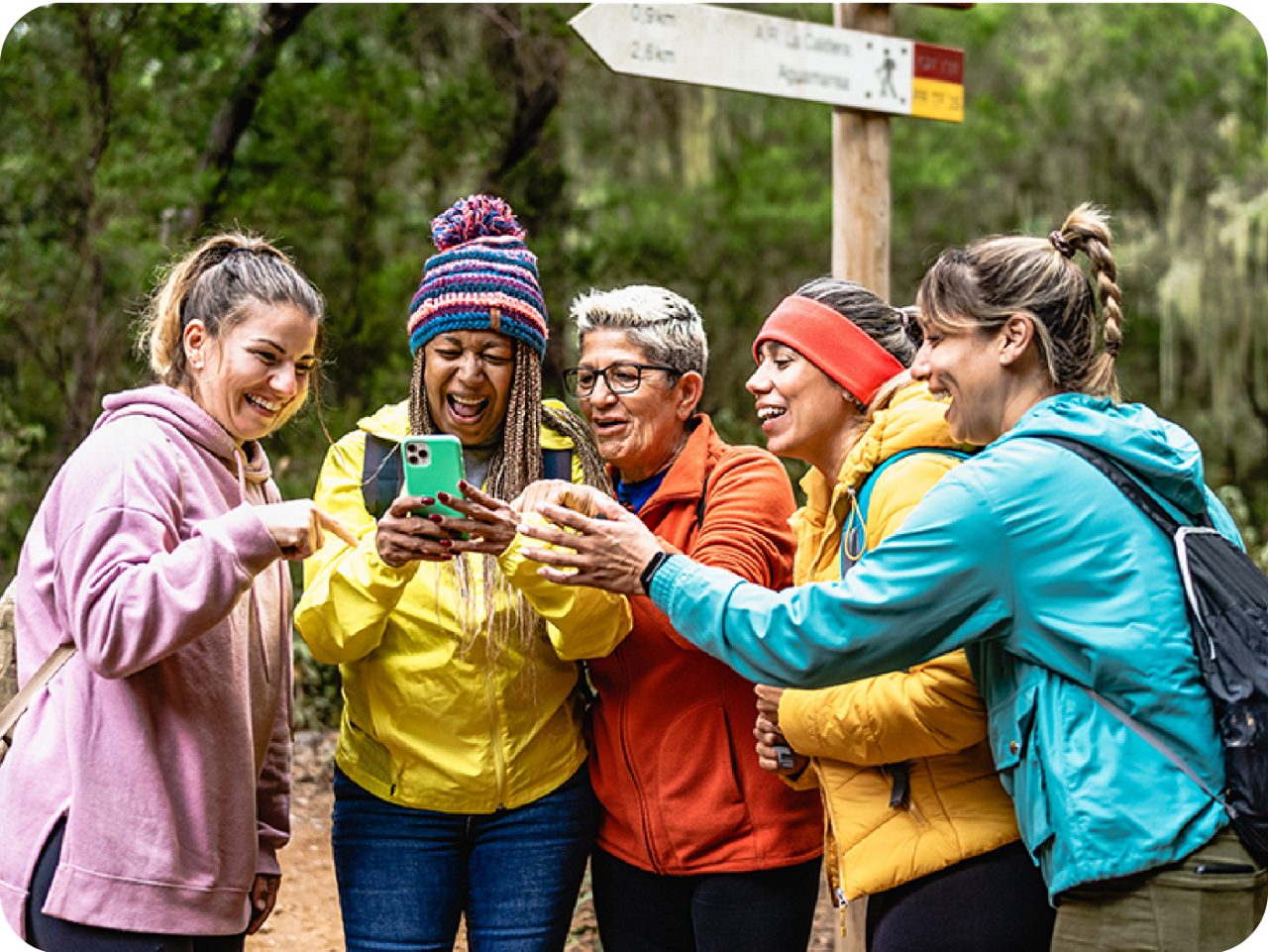 Image of a group of ladies looking to a phone and smiling