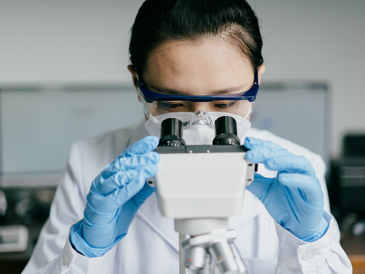 Astellas scientist looking into a microscope at one of the labs.